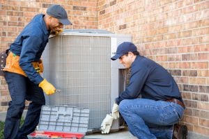 D's Air & Heating, Inc. technicians installing Lennox air conditioner condenser unit in Chicago